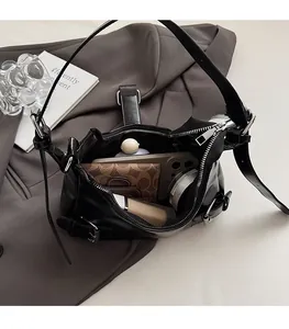 Detail view of the spacious black leather shoulder bag interior holding a phone and wallet