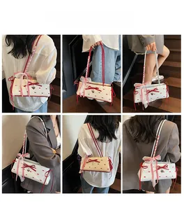 Collage di borsa a spalla color crema con fiocchi rossi e dettagli di ciondolo a cuore