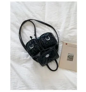 Detail of black quilted leather backpack with silver buckles next to a vintage book
