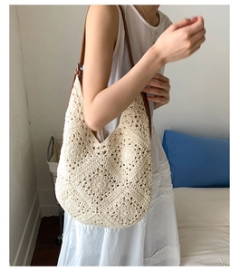 Detail of crochet texture and brown leather strap on cream woven shoulder bag