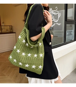 Dettaglio borsa tote in maglia verde con stelle jacquard bianche e tracolla larga