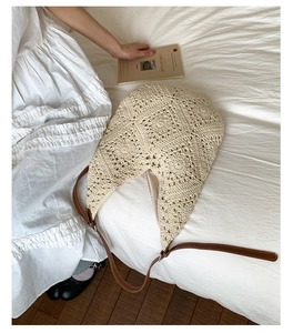 Detailed close-up of summer woven tote bag with hollow geometric patterns and leather straps
