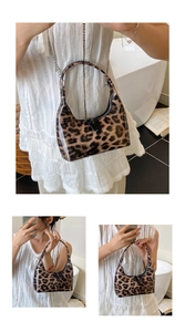 Detail of glossy patent leather leopard print hobo bag with sleek half-moon structure