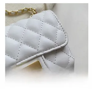 Detail of white quilted leather bag with classic diamond stitch and gold metal turn-lock