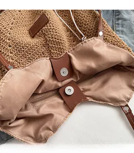 Detail view of woven straw tote bag featuring magnetic closure and inner zipper pocket