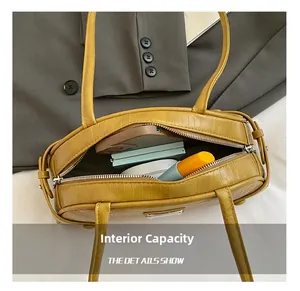 Detail view showing internal capacity of yellow crocodile pattern Boston bag with zipper