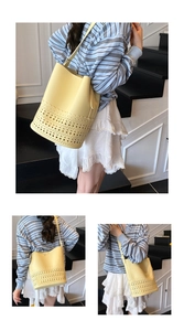 Detail of bright yellow bucket bag featuring laser-cut floral patterns and scalloped edges