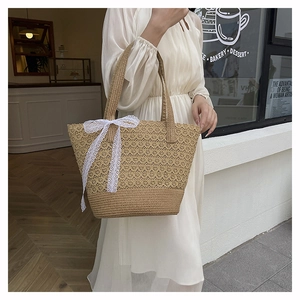 Straw tote bag detail with intricate lace patterns and a large white lace bow accent