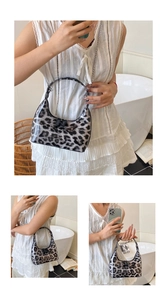 Detail view of leopard print hobo bag with glossy finish and silver chain shoulder strap