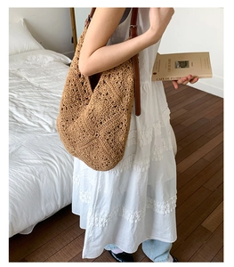 Detail view of khaki crochet sunflower tote bag with brown leather strap in home setting