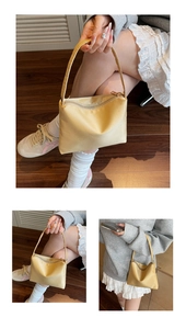 Détail du sac sous le bras en nylon beige montrant le tissu lisse et la fermeture éclair
