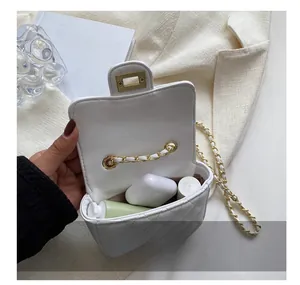 Detailed interior capacity showing daily items in white quilted mini chain bag