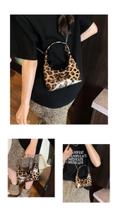 Detailed view of leopard print patent leather handbag with metal chain strap