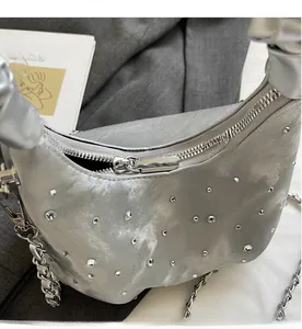 Detail of smooth metal zipper and rhinestone accents on silver leather crescent bag