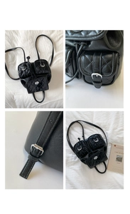 Macro view of black quilted leather texture and silver hardware on a luxury backpack