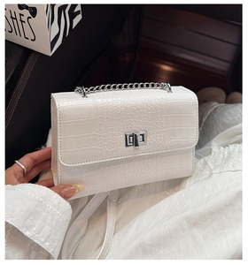 Close-up of white crocodile pattern shoulder bag with silver metal twist lock and chain