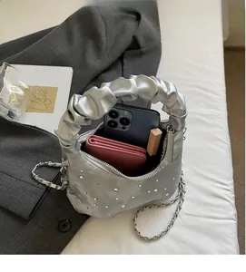 Silver pleated dumpling bag with rhinestones, chain strap, and spacious interior detail