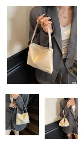 Détail du sac à épaule élégant en satin champagne avec texture lisse et fermeture éclair