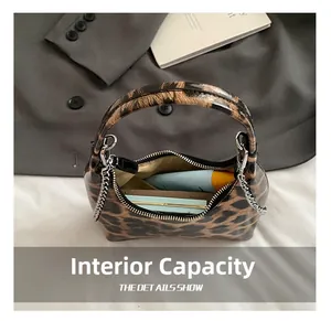 Internal capacity of the leopard print handbag showing essentials and chain detail