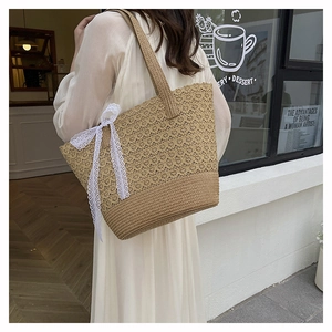 Close-up of woven straw tote bag featuring elegant long white lace ribbon bow details