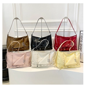 Detailed view of colorful glossy patent leather handbags with metallic industrial punk hardware