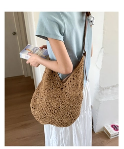 Close-up of brown crochet shoulder bag with geometric patterns and leather strap