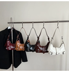 Five glossy faux leather shoulder bags in various colors with silver metal buckle details