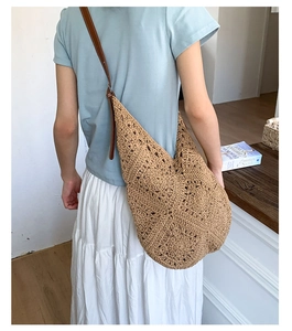 Detail of hand-woven straw tote with premium brown leather strap on model back