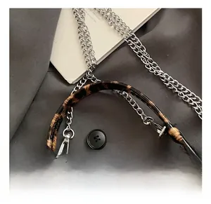 Detail showing leopard print handle and silver metal chain strap on fashion bag