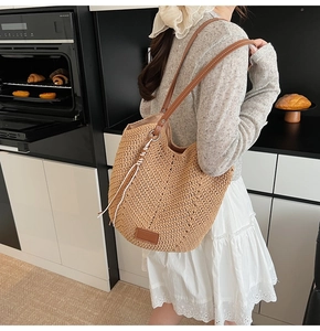 Detailed view of hand-woven straw tote with premium leather straps and vintage texture