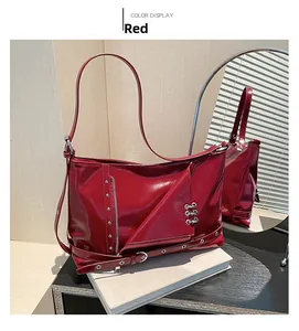 Détail du sac en cuir verni rouge avec rivets, anneaux métalliques et zips verticaux