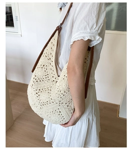 Detailed close-up of ivory hollow crochet tote bag with brown leather handles