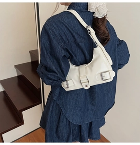 Detail of off-white shoulder bag with silver metallic buckles and premium PU leather