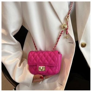Dettaglio mini borsa trapuntata fucsia con catena dorata e sfera in metallo regolabile