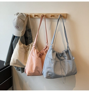 Detailed view of lightweight textured tote bags with drawstring closure and side pockets
