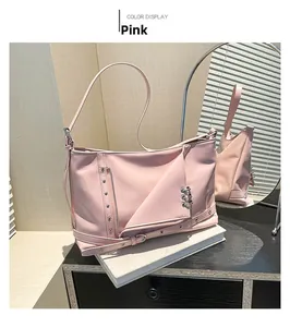 Détail du sac cabas en cuir rose avec rivets métalliques et fermetures éclair décoratives