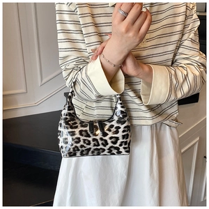 Detail of glossy patent leather texture and leopard print on a vintage style handbag