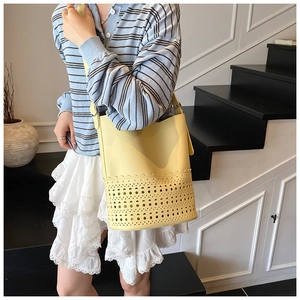 Detail der gelben Beuteltasche mit Laser-Cut-Hohlmustern am Lifestyle-Modell