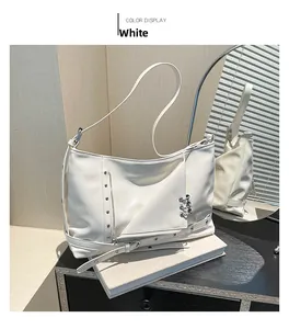 Détail du sac cabas en cuir blanc avec clous punk argentés et anneaux métalliques