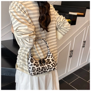 Detail of glossy leopard print handbag with metallic chain strap and chic zipper closure