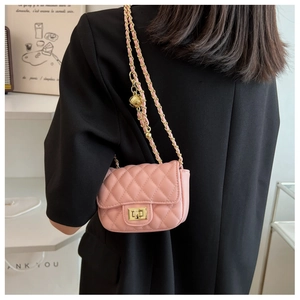 Dettaglio della mini borsa quadrata rosa trapuntata con catena dorata su modella