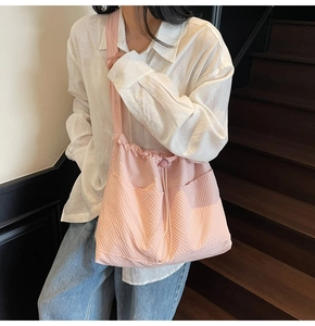 Close-up of pink ruched canvas tote bag featuring drawstring closure and front pockets