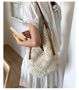 Detail of hollow floral crochet pattern on beige tote bag with adjustable brown strap