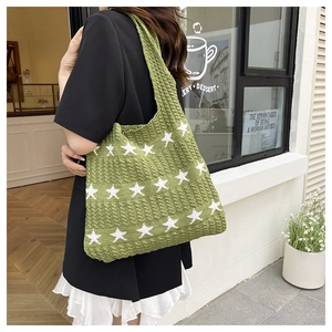 Dettaglio della borsa tote verde intrecciata con stelle e trama a maglia fitta