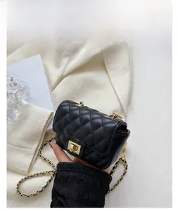 Detail of black quilted mini saddle bag with golden twist lock and chain strap