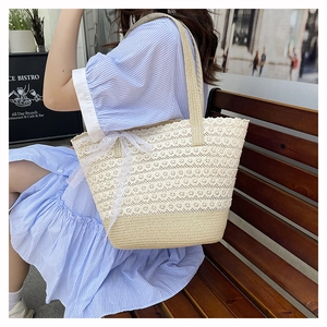 Detail of summer lace woven tote bag with straw texture and large white ribbon bow