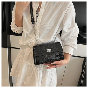 Detailed view of crocodile texture shoulder bag with silver metal twist lock and chain strap