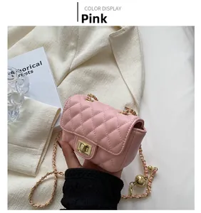 Detail of pink quilted crossbody bag with golden chain and metal ball decorative clasp