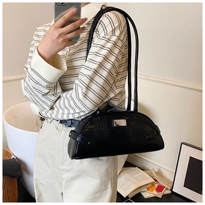 Black crocodile embossed half-moon shoulder bag shown on model for realistic size