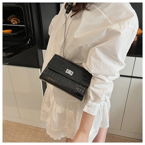 Macro detail of black crocodile texture PU leather shoulder bag with silver turn-lock